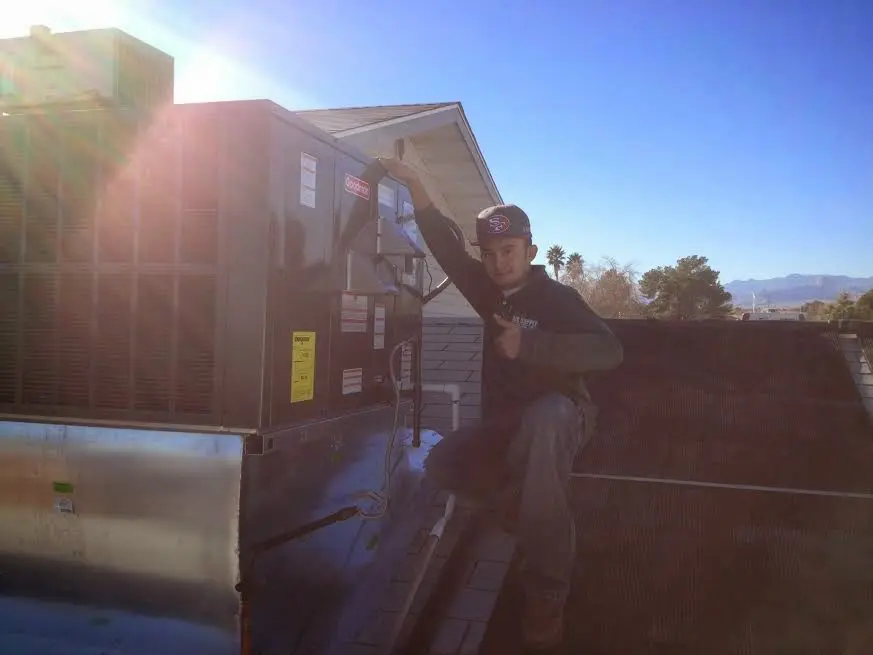 HVAC technician performing Air Duct Cleaning on a rooftop unit in Elk Plain